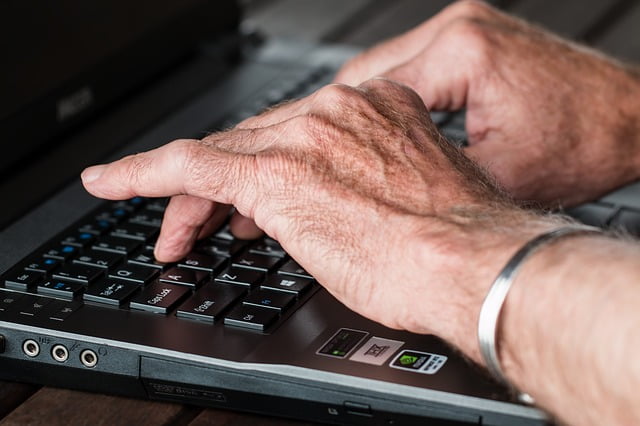Working senior hand typing laptop